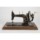LATE 19th CENTURY TABLE TOP SEWING MACHINE with folding handle, gilt Greek key and foliate scroll