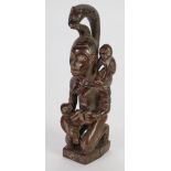 REPUBLIC OF CONGO CARVED WOOD MATERNITY FIGURE, modelled seated, feeding a baby from a large cup,