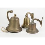 HEAVY BRASS BULKHEAD TYPE BELL PIVOTING ON A SCROLL SHAPED WALL BRACKET, 8" (20.3cm) diameter, lacks