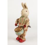 MID TWENTIETH CENTURY TINPLATE AND FELT FABRIC CLOCKWORK DRUMMING RABBIT, depicted standing an