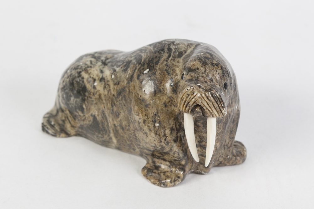 AN INUIT CARVED STONE MODEL OF A WALRUS, with walrus ivory tusks, signed 'Made in Alaska by Larry