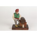 TRYGG-NORWEGIAN TWENTIETH CENTURY CARVED SOFTWOOD AND PAINTED FIGURE OF A MAN STANDING BESIDE A BEER