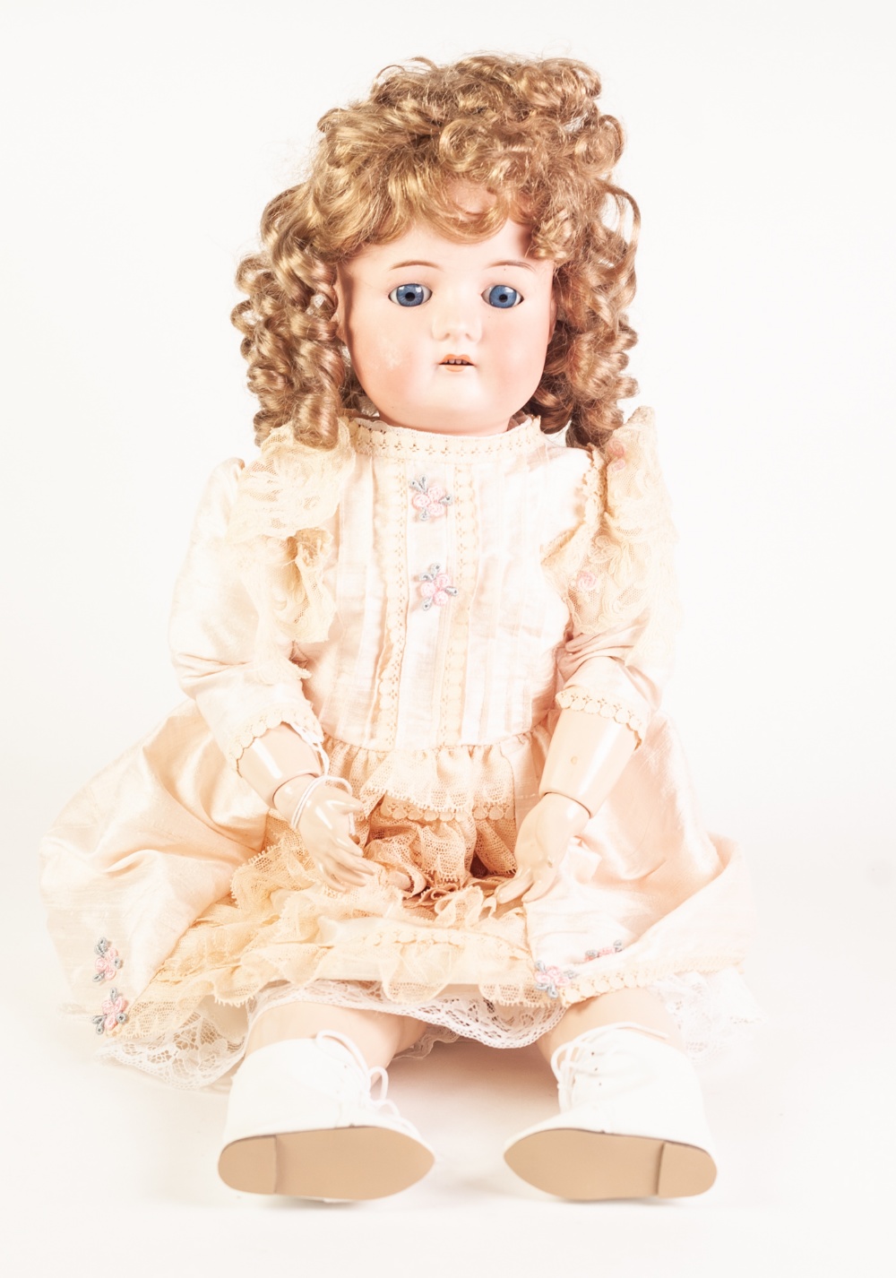 A GERMAN BISQUE HEAD DOLL, with fixed blue eyes and open mouth, on later ball jointed composition
