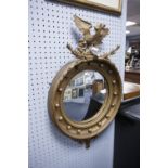 REGENCY STYLE GILT FRAMED CONVEX WALL MIRROR, WITH EAGLE CREST AND TYPICAL BALL ORNAMENT