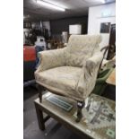 A SMALL EARLY TWENTIETH CENTURY TUB SHAPED EASY CHAIR WITH SCROLL FRONT SUPPORTS