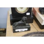 A BLACK 'STONE' MODEL OF AN EGYPTIAN SPHINX, 5" LONG