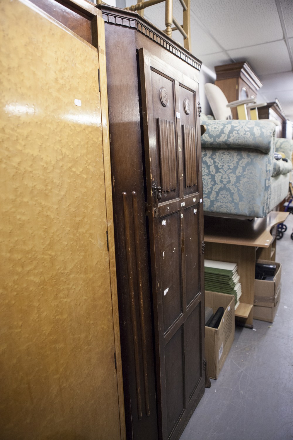 A MID TWENTIETH CENTURY DARK OAK HALLROBE, DENTIL CORNICE, OVER CANTED CORNERS, THE PANELLED DOORS