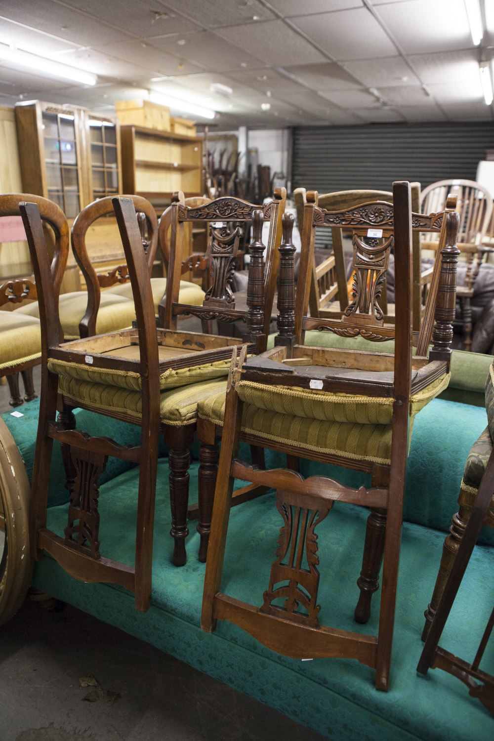 SET OF FOUR LATE VICTORIAN CARVED WALNUTWOOD DINING CHAIRS WITH PIERCED SPLAT BACKS AND STUFF OVER