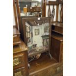 VICTORIAN FIRE SCREEN, OAK FRAME WITH NEEDLEWORK SCENE OF A SEATED WOMAN READING AND A NINETEENTH