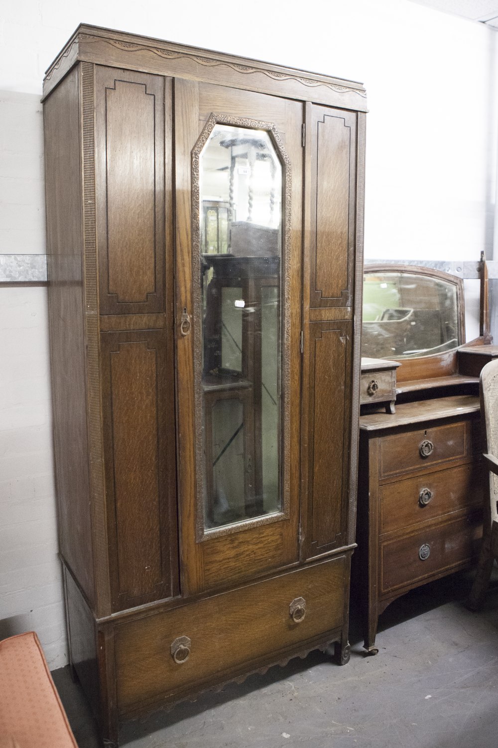 AN EARLY TWENTIETH CENTURY OAK DRESSING CHEST, THE SHAPED SWING MIRROR ON STAND WITH DRAWER TO