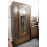 AN EARLY TWENTIETH CENTURY OAK DRESSING CHEST, THE SHAPED SWING MIRROR ON STAND WITH DRAWER TO