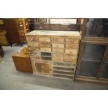 A NEST OF SMALL DRAWERS AND CUPBOARD WITH BRASS KNOB HANDLES (SOME DRAWERS MISSING)