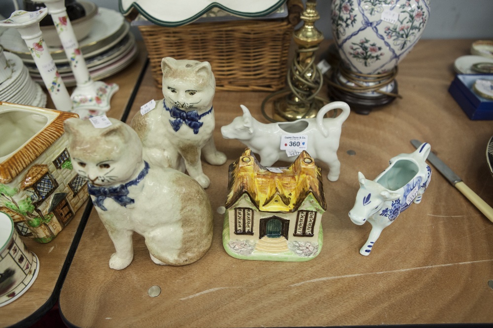 PAIR OF NINETEENTH CENTURY STAFFORDSHIRE POTTERY MODELS OF SEATED CATS, WITH FRONT PAWS AWAY FROM