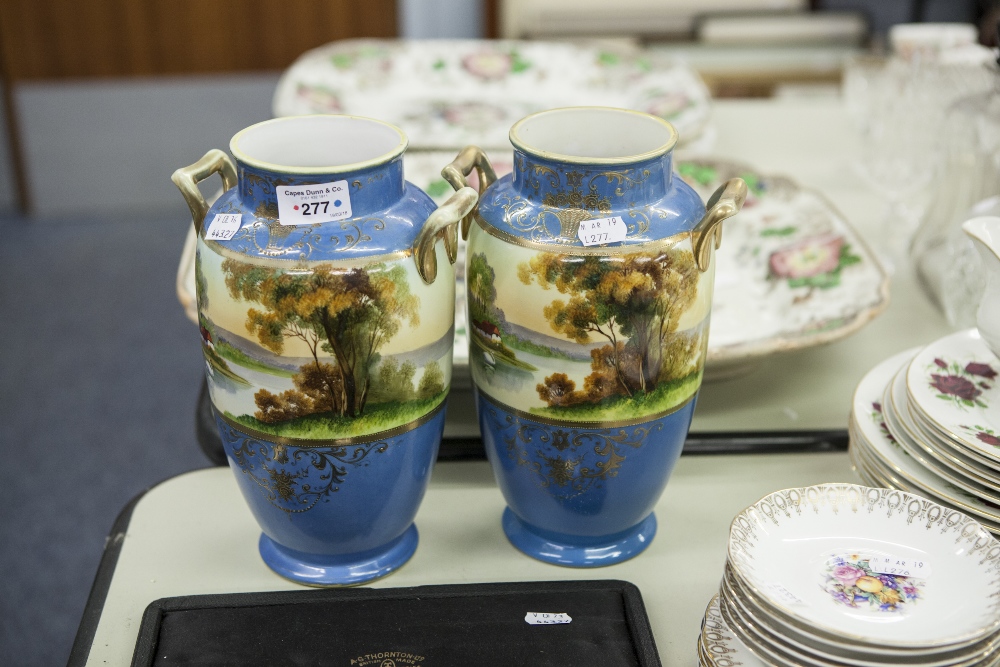 A PAIR OF NORITAKE SATSUMA VASES WITH HANDLES, GILT HIGHLIGHTS, PAINTED WITH LAKE SCENES (2)