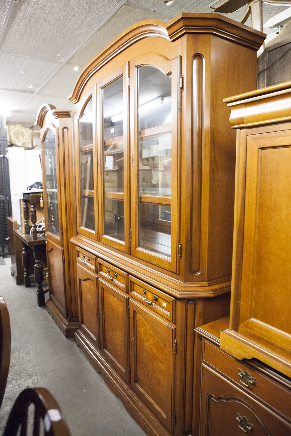 A MAHOGANY TALL SIDE CABINET WITH LOW ARCHED MOULDED CORNICE, THREE GLAZED DOORS ENCLOSING A