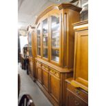 A MAHOGANY TALL SIDE CABINET WITH LOW ARCHED MOULDED CORNICE, THREE GLAZED DOORS ENCLOSING A
