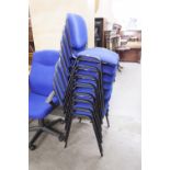 EIGHT DARK BLUE FABRIC COVERED STACKING SINGLE CHAIRS