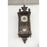 A VIENNA WALL CLOCK, BRASS FACE WITH CREAM CHAPTER RING, BLACK ROMAN NUMERALS, TYPICAL CASE WITH