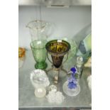 A COLOURED GLASS TRUMPET VASE ON METAL STAND, A COLOURED GLASS DOLPHIN ORNAMENT AND THREE OTHER