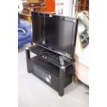 A PANASONIC FLAT SCREEN TV. ON BLACK GLASS STAND