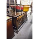 AN EDWARDIAN OAK SIDEBOARD WITH RAISED BACK