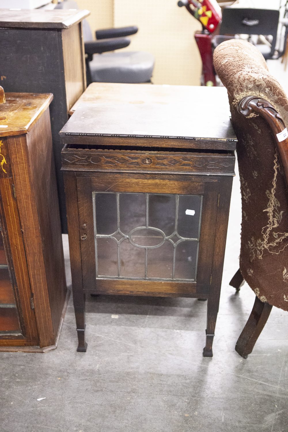 AN OAK SMALL DISPLAY CABINET, WITH GLAZED AND LEADED DOOR AND LIFT UP TOP TO REVEAL A CANTEEN OF