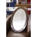 AN OVAL BEVELLED EDGE WALL MIRROR, IN OAK FRAME