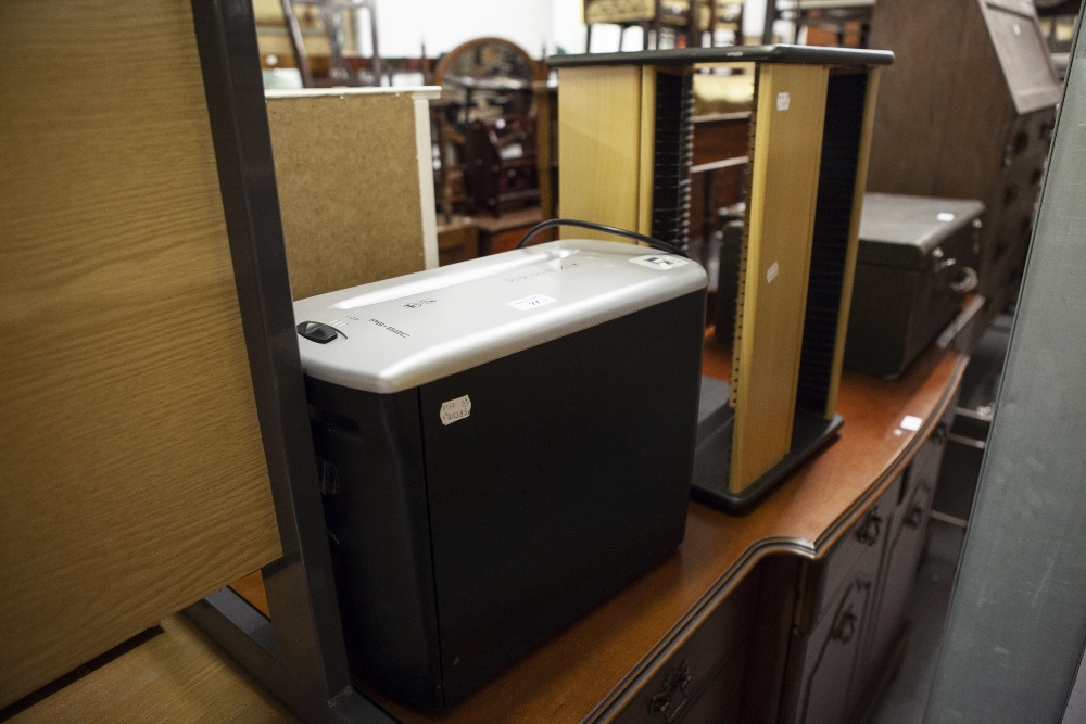 A FOUR SIDED CD STORAGE RACK (FLOOR STANDING) AND AN ELECTRIC PAPER SHREDDER