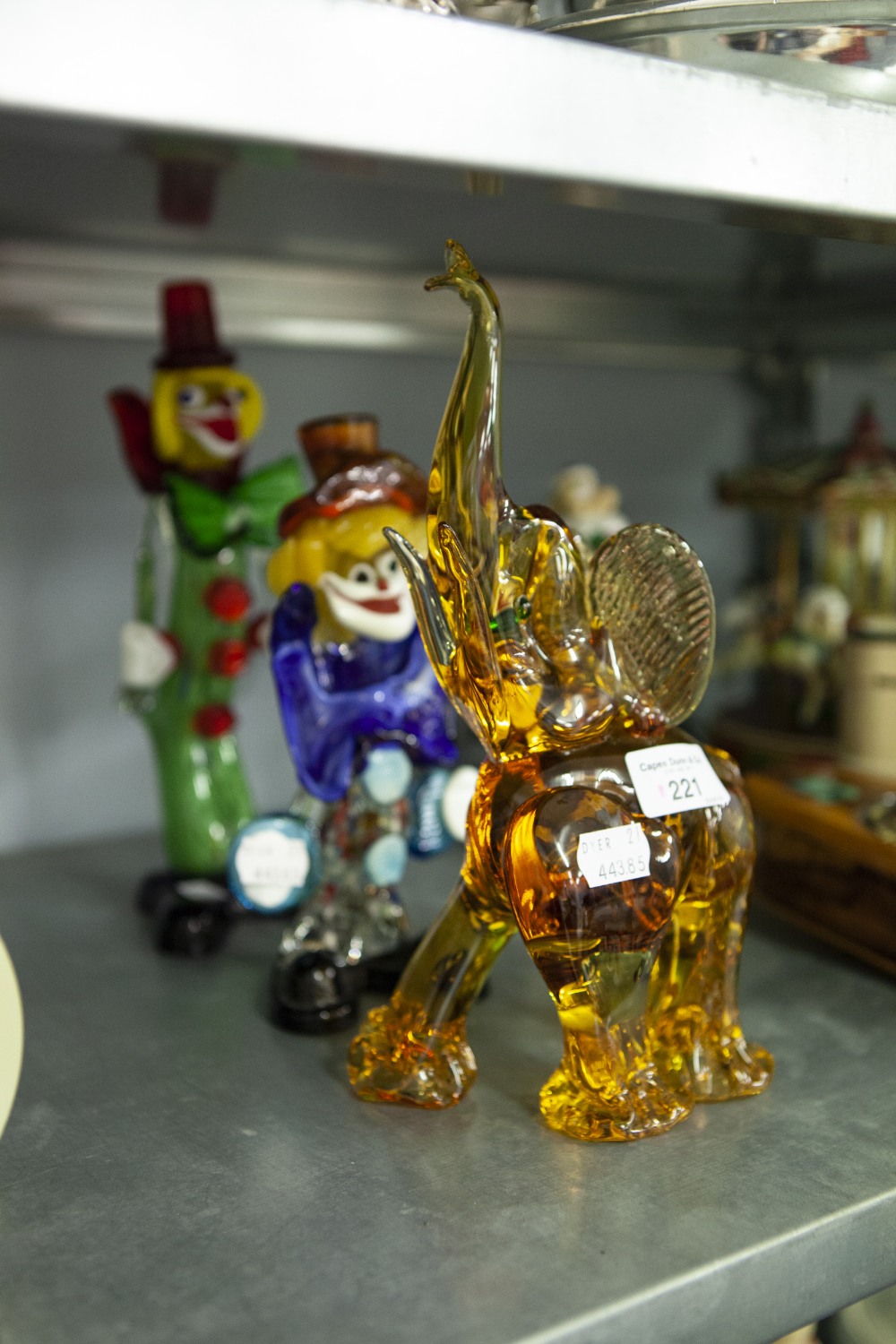 TWO COLOURED GLASS FIGURES OF CLOWNS AND A PINK GLASS ELEPHANT ORNAMENT (3)