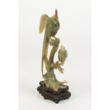 LATE NINETEENTH/EARLY TWENTIETH CHINESE CARVED GREEN HARDSTONE MODEL OF AN EXOTIC BIRD, perched upon