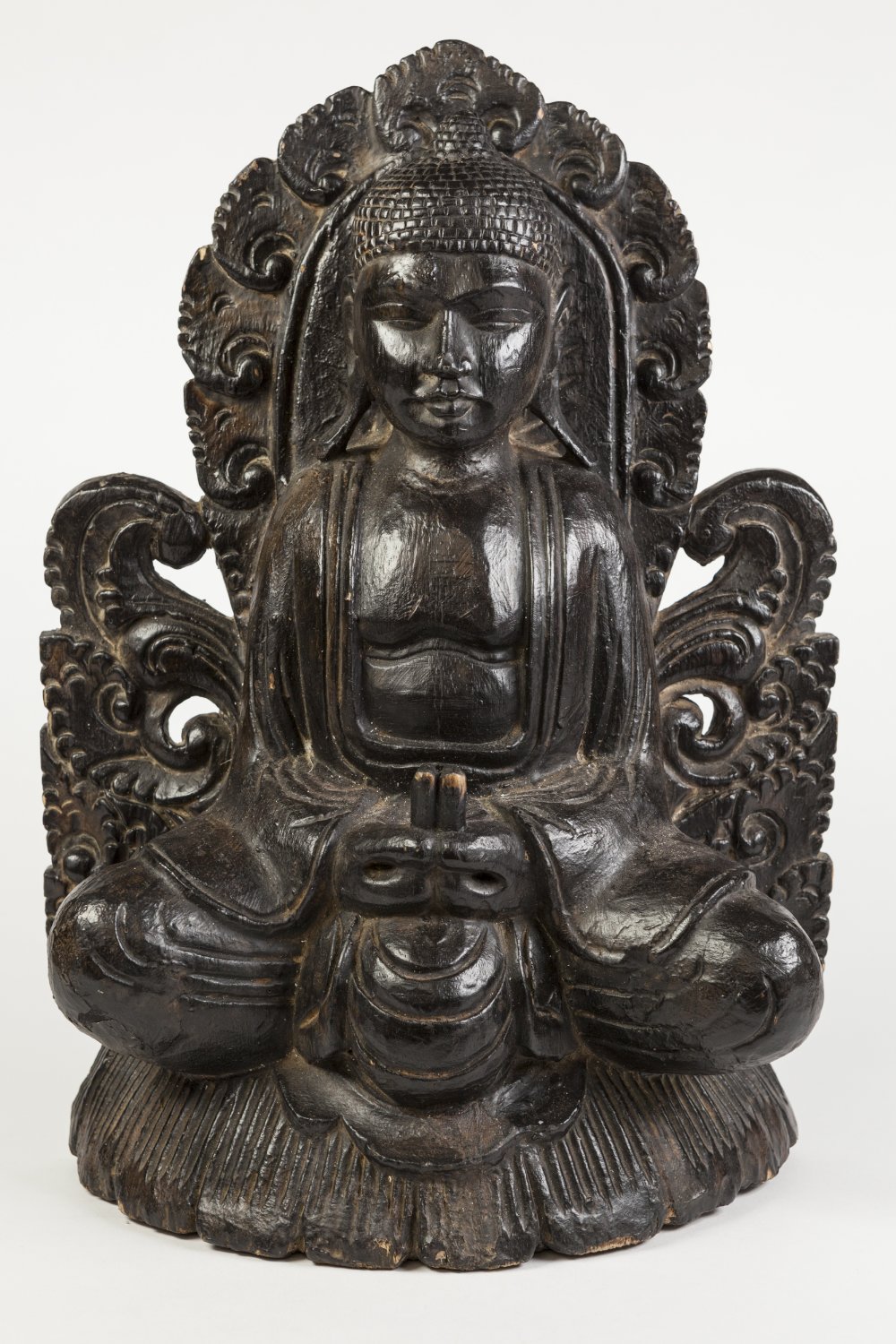 NINETEENTH CENTURY ORIENTAL CARVED AND EBONISED SOFTWOOD FLAT BACKED FIGURE OF BUDDHA, seated