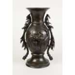 AN EARLY TWENTIETH CENTURY JAPANESE PATINATED BRONZE VASE, cast in relief with cranes amongst