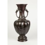 A JAPANESE MEIJI PERIOD DARK BROWN PATINATED BRONZE TWO HANDLED PEDESTAL VASE, the lobated ovoid