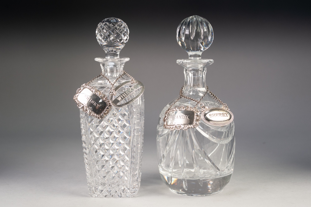 TWO GOOD QUALITY CUT GLASS DECANTERS with two modern SILVER WINE LABELS, and two metal ditto