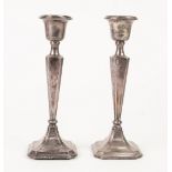 A PAIR OF SILVER CANDLESTICKS, with fluted tapering stems on square pedestal bases with chamfered