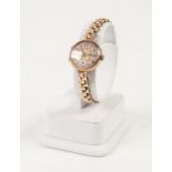 a 9ct GOLD LADY'S WRIST WATCH, on rolled gold linked bracelet (seconds hand detached)