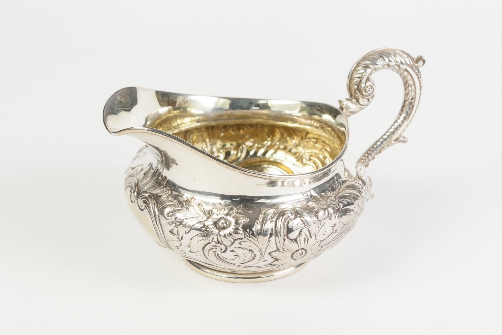 A GOOD QUALITY WILLIAM IV SILVER CREAM JUG, with gilded interior, of compressed form, the body