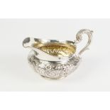 A GOOD QUALITY WILLIAM IV SILVER CREAM JUG, with gilded interior, of compressed form, the body