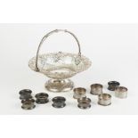 A LATE VICTORIAN SILVER STAMPED AND PIERCED SWING HANDLED CAKE BASKET, on a circular domed