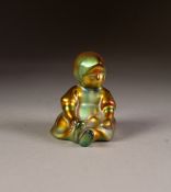 ZSOLNEY PECS, HUNGARIAN LUSTRE GLAZED POTTERY FIGURE OF A SEATED CHILD, 2 ¾" (7cm) high, printed