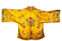 A PAIR OF CHINESE YELLOW SILK PYGAMAS, colourfully embroidered with flowers, TOGETHER WITH A PAIR OF