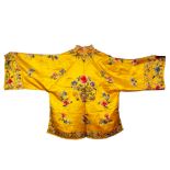 A PAIR OF CHINESE YELLOW SILK PYGAMAS, colourfully embroidered with flowers, TOGETHER WITH A PAIR OF