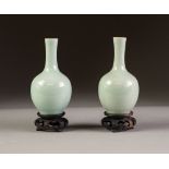 PAIR OF CHINESE CELADON GLAZED PORCELAIN SMALL VASES, each of bottle form, with carved decoration, 4