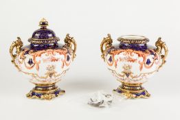 PAIR OF ROYAL CROWN DERBY PORCELAIN TWO HANDLED PEDESTAL URNS AND COVERS, each of oval form with