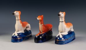 PAIR OF 19th CENTURY STAFFORDSHIRE POTTERY MODELS OF RECUMBENT GREYHOUNDS, on dark blue glazed