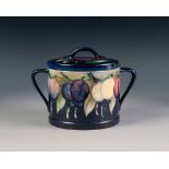 WALTER MOORCROFT 'WISTERIA' PATTERN TUBE LINED POTTERY TWO HANDLED BISCUIT BARREL AND COVER, of