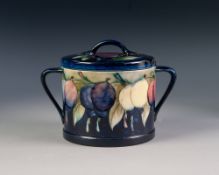 WALTER MOORCROFT 'WISTERIA' PATTERN TUBE LINED POTTERY TWO HANDLED BISCUIT BARREL AND COVER, of