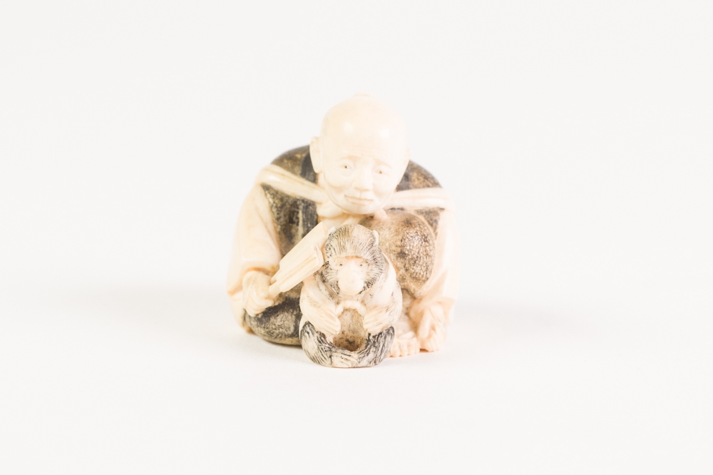 GOOD JAPANESE MEIJI PERIOD CARVED AND, IN PART, DARK STAINED IVORY NETSUKE OF A MAN WITH A PET - Image 3 of 4