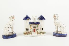 PAIR OF VICTORIAN STAFFORDSHIRE POTTERY SEATED DALMATIANS on blue glazed oval bases, 5 1/4" (13.5cm)