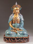 A CHINESE LATE QING/REPUBLIC PERIOD PORCELAIN MODEL OF A BUDDHA seated cross legged holding in the